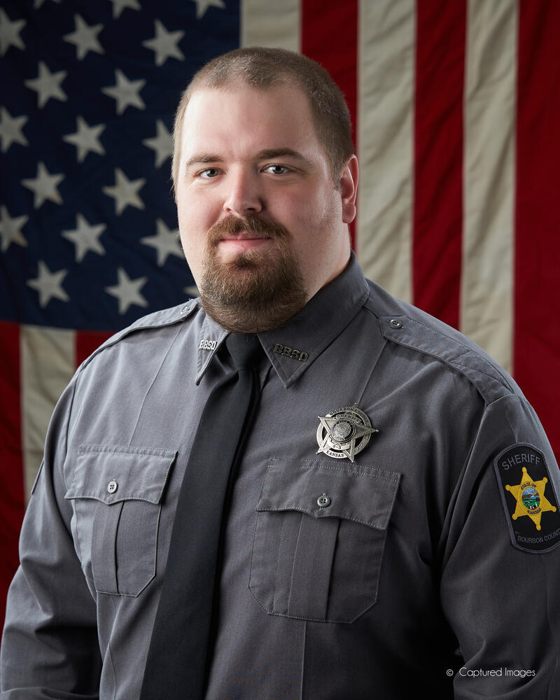 Deputy Zach Ross in dress blue uniform with silver badge on left chest